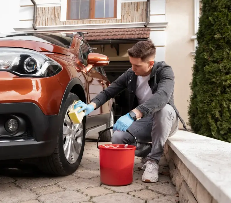 Lavage auto à domicile Nézignan-l'Évêque : professionnel intervenant sur un véhicule
